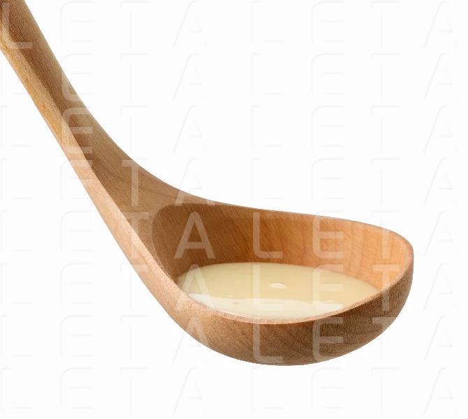 condensed milk in wooden ladle