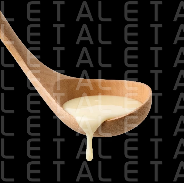 condensed milk in wooden ladle