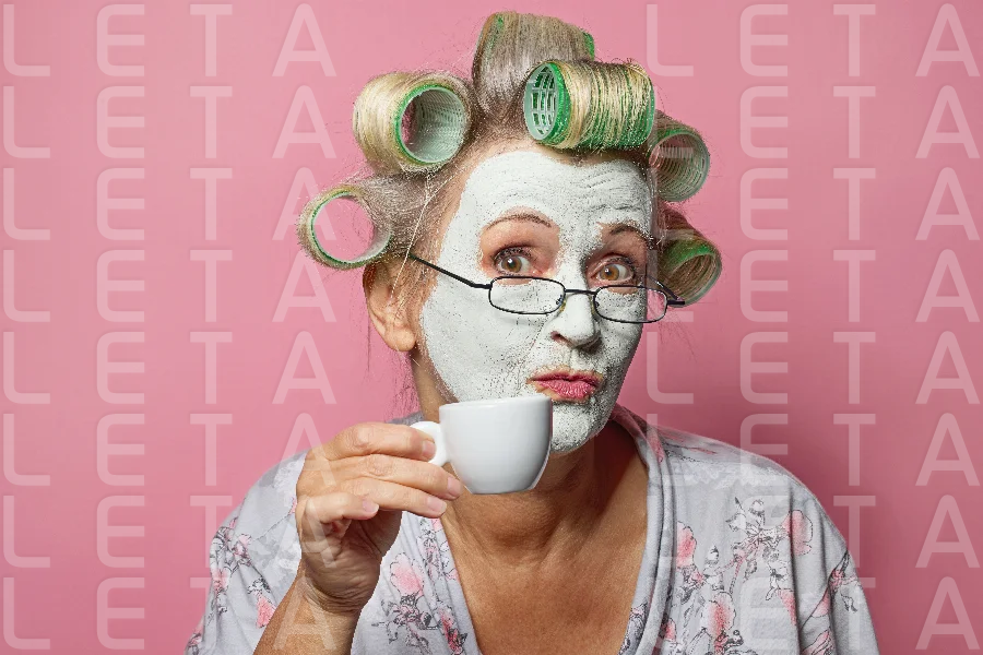 funny senior woman with cosmetic face mask