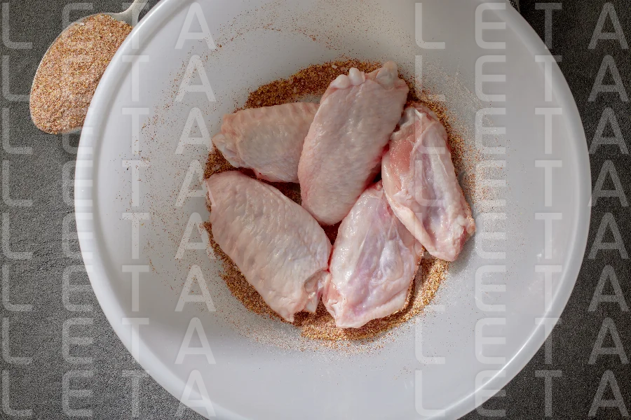 fresh raw chicken wings in bowl of spices