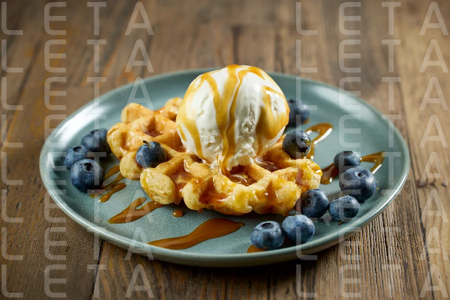 plate of belgian waffle with caramel sauce and blueberries