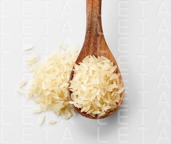 raw rice in wooden spoon