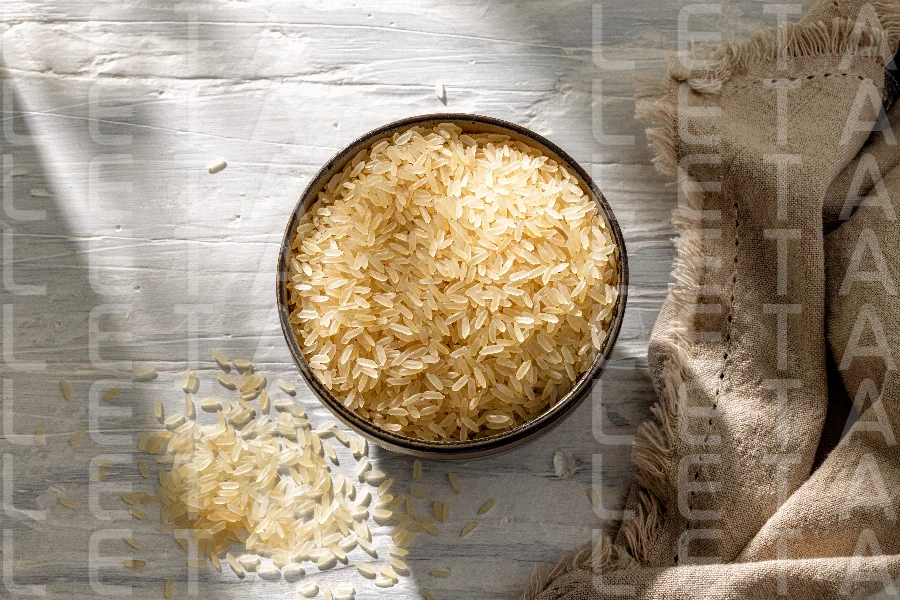bowl of raw rice on white sunny rustic kitchen table
