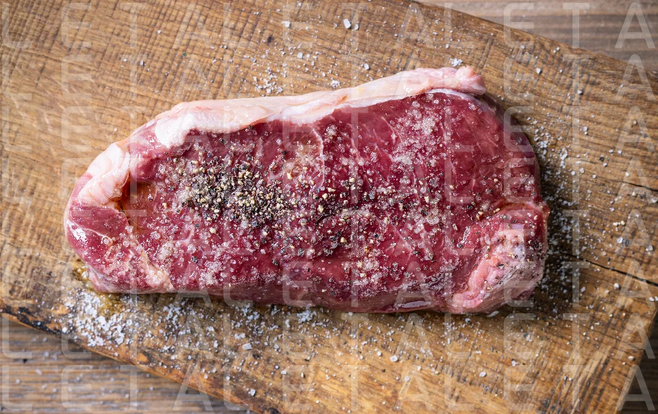 fresh raw beef steak meat with salt and pepper on wooden cutting