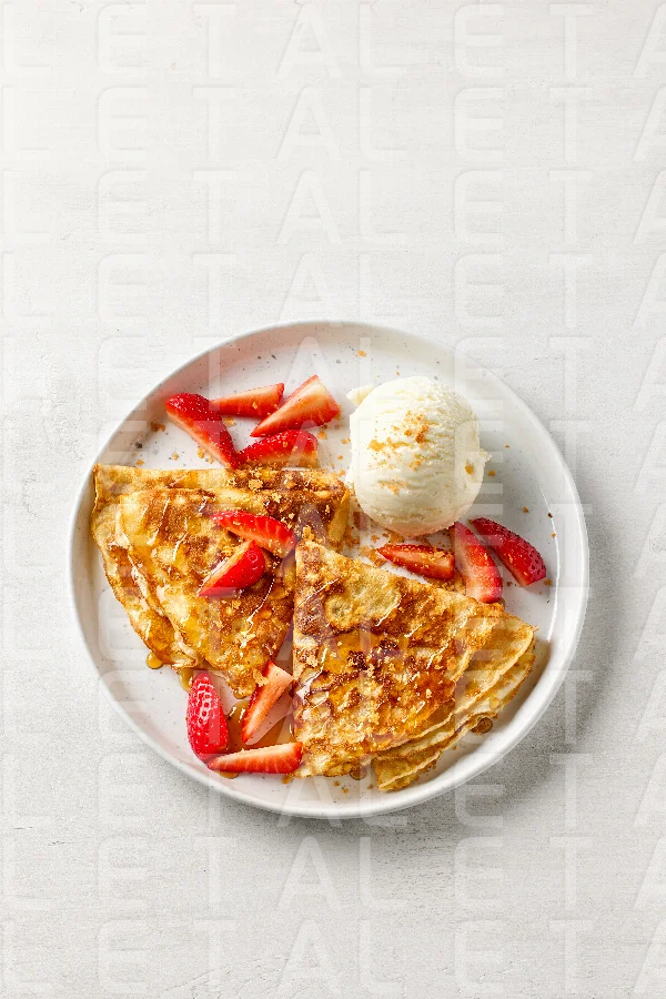 crepes decorated with honey, strawberries and ice cream